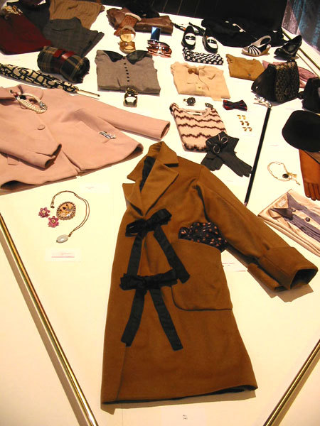 Manteau fermé par des liens ruban All (D.R.) Manteau fermé par des liens ruban All (D.R.)