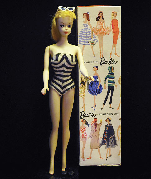 Barbie vintage avec une planche de vêtements créés pour elle.